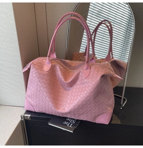 Detail of pink woven leather tote bag with reinforced corners and premium texture