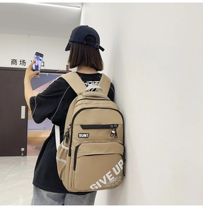 Close-up of khaki large capacity backpack with GIVE UP letter print on a male model