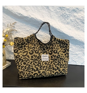 Close-up of leopard print tote bag with fabric texture and central square logo detail