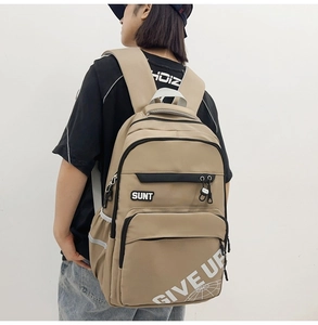 Detail of khaki nylon backpack featuring reflective strips and SUNT print design