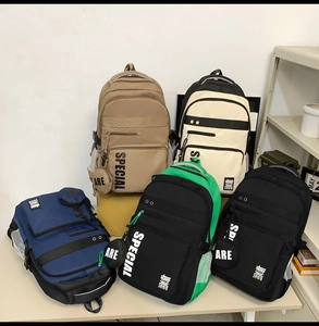 Detail of multi-color nylon backpacks featuring SPECIAL print and hanging pouch accessory