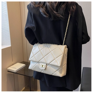 Quilted crossbody bag with gold chain strap and turn-lock closure on model