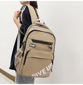 Side view of beige backpack showing GIVE UP printed graphics and reflective strip
