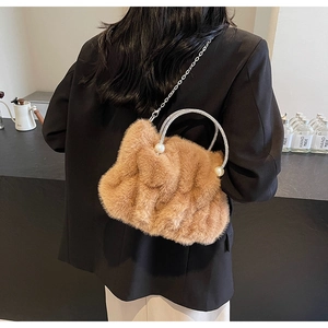 Detail van bruine tas van imitatiebont met handvat van strass en parelaccenten
