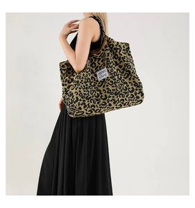 Detail view of large leopard print tote bag featuring a leather patch and spacious interior