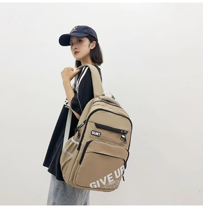 Detailed view of khaki large capacity backpack with SUNT label and multi-pocket design