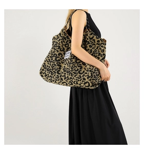 Macro shot of the leopard print fabric texture and logo patch on this large tote bag