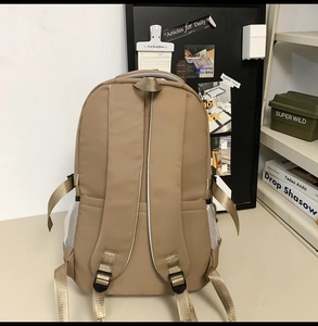 Detail view of khaki backpack back with adjustable shoulder straps and mesh side pockets