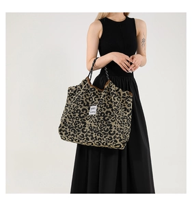 Detailed view of large leopard print tote bag with woven texture and braided handles