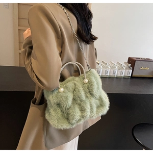 Detail van lichtgroene tas van imitatiebont met strass handvat en parels