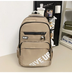 Detail view of khaki durable canvas backpack with SUNT label and GIVE UP graphic print