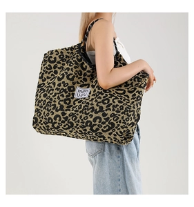 Detail view of the large leopard print tote bag fabric with white mmn uuu woven label