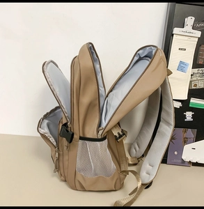 Detail view of khaki waterproof backpack with three zippered layers and breathable straps