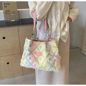 Détail du sac cabas en denim à motif étoile avec bords effilochés et design patchwork