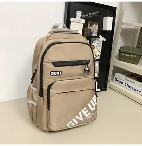 Detail of khaki nylon backpack featuring white Give Up print and durable zip pockets