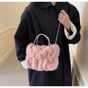 Detail van roze imitatiebont tas met parel handvat en zilveren schouderketting
