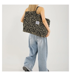 Close-up of leopard print tote bag with brand label and durable canvas texture