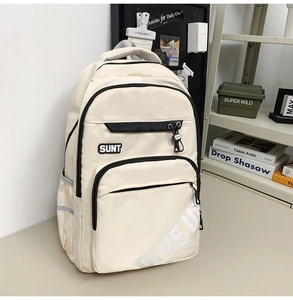 Detail view of durable beige nylon fabric with SUNT letter patch and black zipper accents