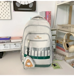 Détail du sac à dos crème avec poches multiples et porte-monnaie en forme de pizza