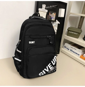 Detail view of black nylon backpack featuring white text print and reflective side strips