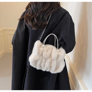 Detail van pluche cloudtas met strass handvat, parelaccenten en zilveren ketting
