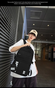 Detail view of large capacity black backpack with white letters and side zipper mesh pocket