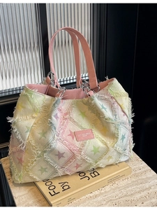 Sac fourre-tout en denim à motifs étoiles colorées et bordures effilochées sur marbre