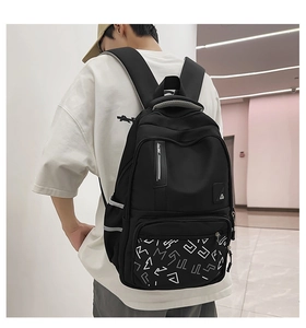 Close-up of black nylon backpack featuring geometric letter patterns and reflective strips
