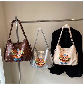 Detailed view of large tote bags with cartoon burger cat print in brown, silver, and white