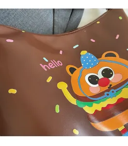 Detail of soft brown PU leather featuring a cartoon burger bear print and hello text