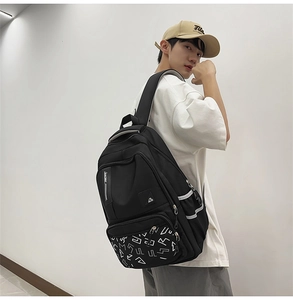 Detail view of large capacity black nylon backpack with reflective strips and zipper pockets