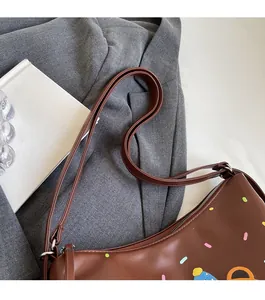 Detailed close-up of brown synthetic leather tote bag with colorful polka dot graffiti