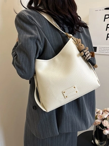 Minimalist beige pebble leather bucket bag with an adjustable strap and cute rabbit charm