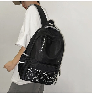 Detailed side view of black backpack with geometric camo front pocket and RACING tag