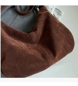 Detail shot of deep brown suede tote bag showing soft texture and precision stitching