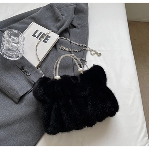 Detail van zwarte faux fur tas met strass handvat, parels en zilveren kettingriem