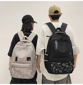 Detail view of large capacity school backpacks in light grey and black nylon fabrics