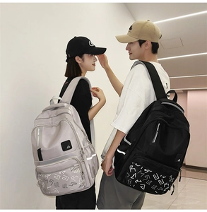 Lifestyle shot of black and silver large capacity backpacks with geometric print details