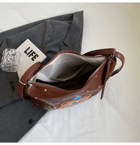 Detail view of the brown cartoon bear bag interior showing spacious lining and zipper pocket