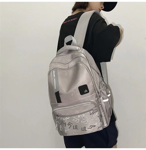 Detail of light grey satin backpack showing side pocket and racing ribbon detail