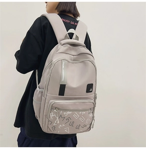 Detail of light grey student backpack with Racing ribbon straps and zip pockets