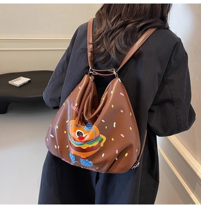 Brown PU backpack with cartoon burger print and slogans shown on a model's back