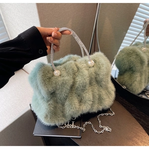 Detail van lichtgroene handtas van imitatiebont met strass handvat en parelaccenten