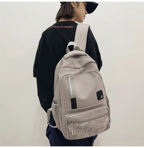 Close-up of the multi-pocket nylon backpack with Racing tape and geometric prints