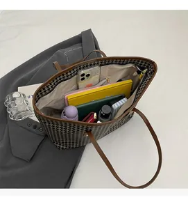 Detail view of large houndstooth tote interior showing spacious capacity and zip pocket