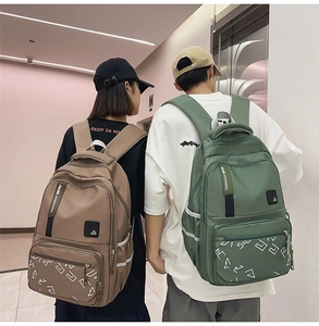 Dual student backpacks in coffee and sage green colors with reflective strips and multi-pockets