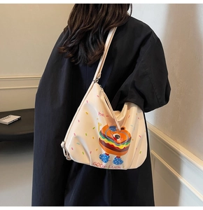 Detail of cute burger cartoon tote bag with adjustable strap shown on model's shoulder