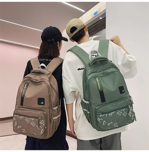 Detail of multi-compartment nylon backpack featuring reflective strips and side logos
