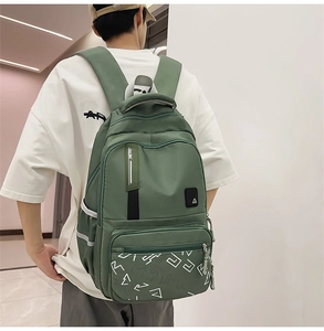 Close-up of minimalist green backpack showing side mesh pocket and racing webbing detail