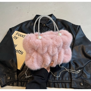 Detail van roze faux fur cloud bag met parelhandvatten en een zilveren kettingriem